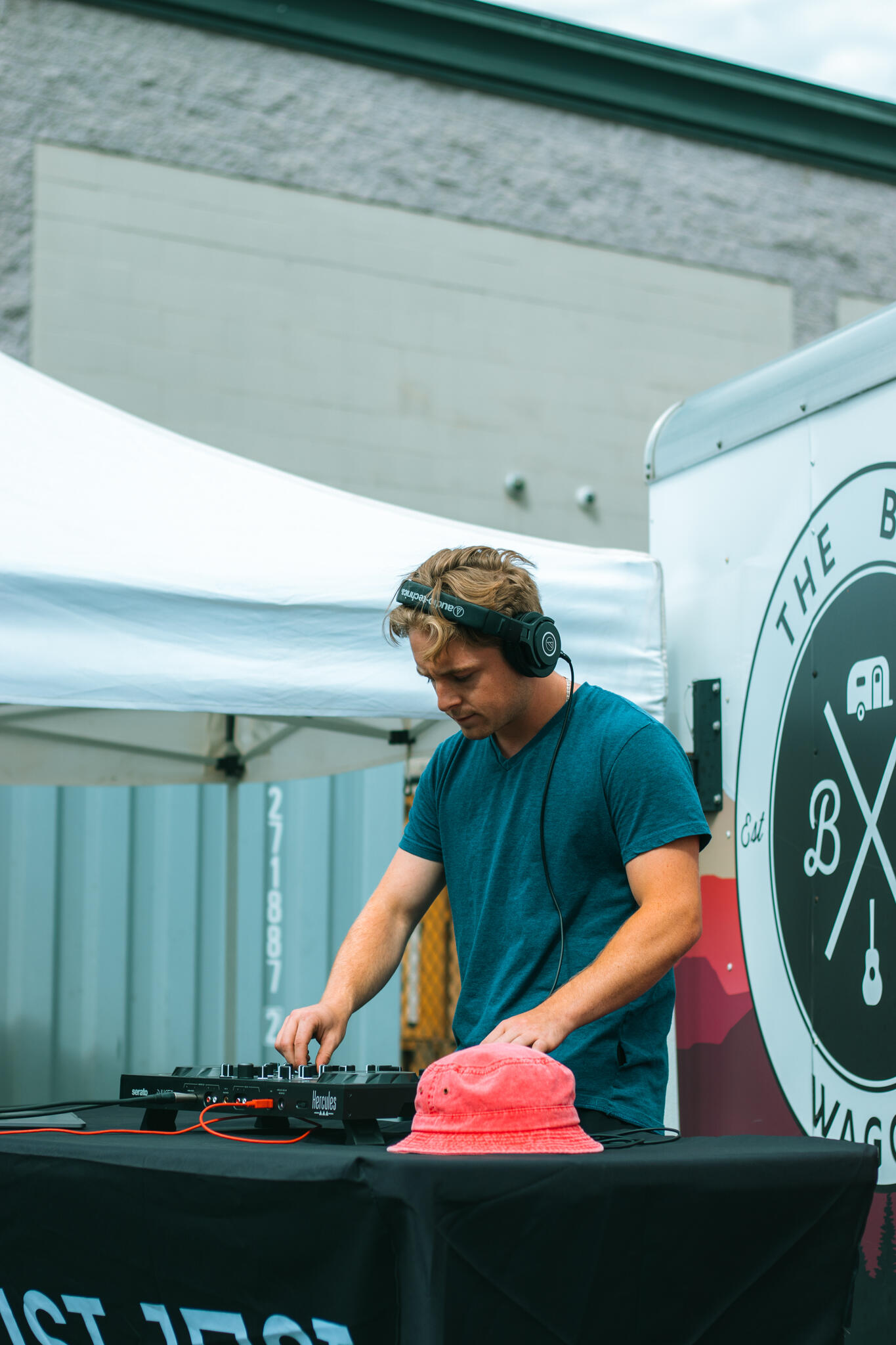 A man is engaged in mixing music at a DJ table, showcasing his skills as colorful lights create a lively ambiance around him.