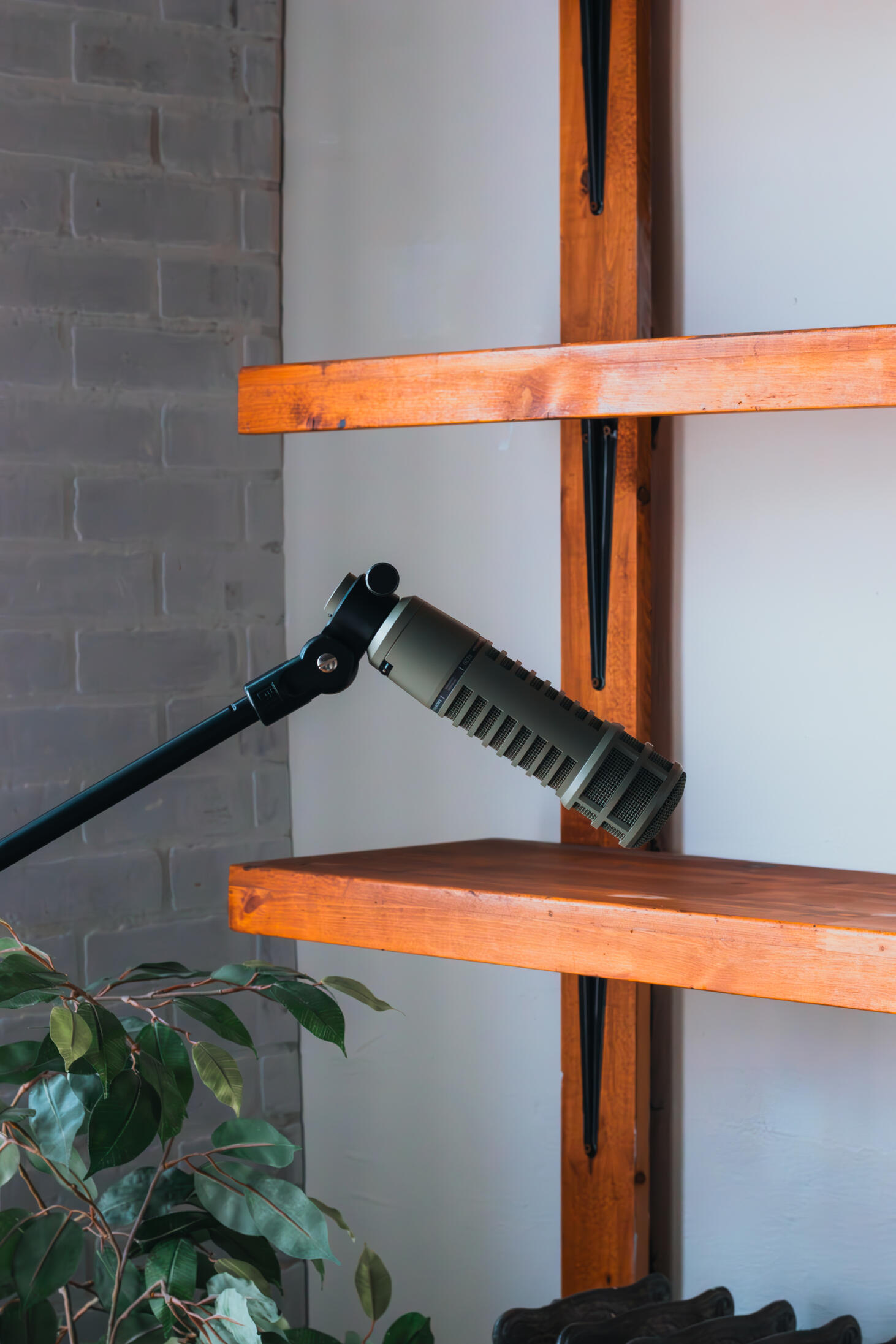 Multiple high-quality MIDI pianos and devices used to produce, mix, and master different music tracks, featured on a clean wood shelf with light shining on them.