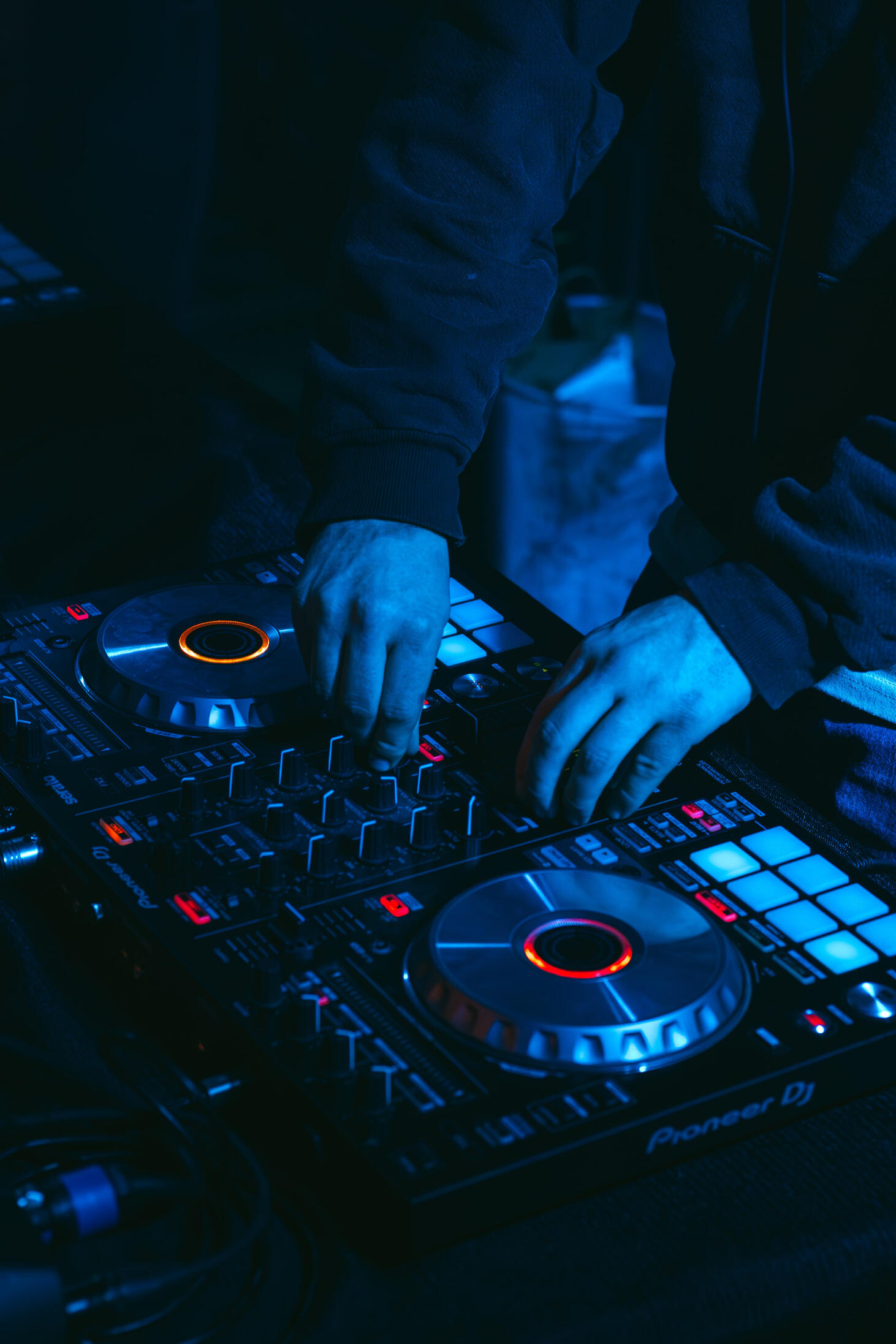 Multiple high-quality MIDI pianos and devices used to produce, mix, and master different music tracks, featured on a clean wood shelf with light shining on them.